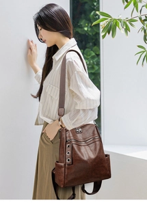 Detail of premium brown faux leather texture and metallic eyelet decor on a backpack