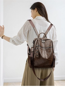 Detailed back view of a dark brown vintage PU leather backpack with silver zippers