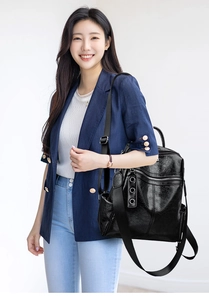 Detail of vintage black faux leather backpack with metallic buckle rings on a model
