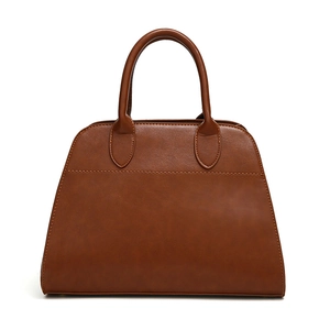 Retro brown leather tote bag with round handles and trapezoidal silhouette in high-key white