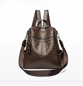 Detail view of brown vintage leather backpack with textured finish and zipper pockets