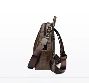 Side view of dark brown vintage backpack showing lychee texture and metallic hardware
