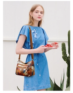 Borsa a tracolla in pelle patchwork con tasche a zip indossata da una modella all'aperto