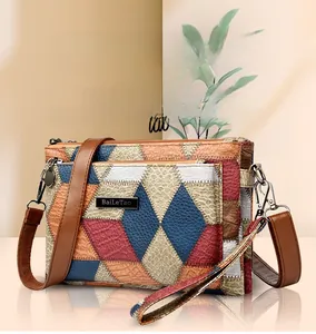 Detail of color-block patchwork crossbody bag with textured leather and metal logo