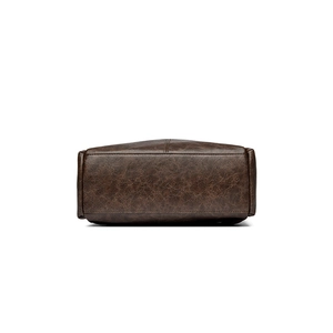 Close-up of bottom base of a vintage brown leather backpack with clean stitching