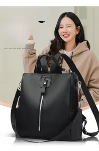 Close-up of black pebble faux leather backpack with vertical silver zipper on a model
