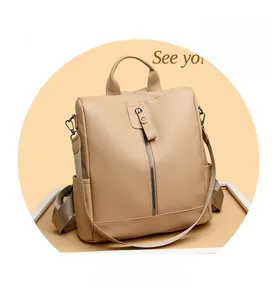 Detail of waterproof cream oxford backpack showing leather handle and vertical zipper pocket