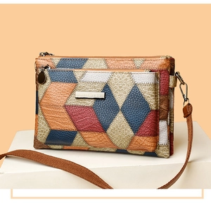 Detail view of colorful geometric patchwork leather crossbody bag with triple zippers