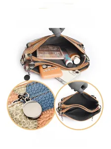 Multi-compartment crossbody bag detail showing pebble leather and color block design