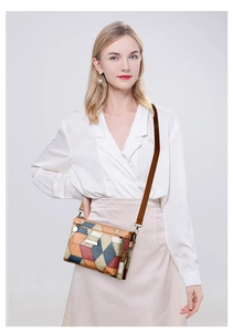 Detail of color-block patchwork clutch bag with geometric leather and gold plaque