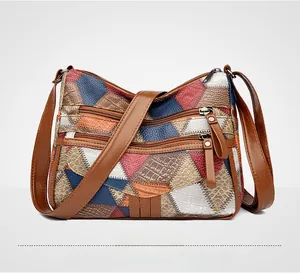 Dettaglio borsa patchwork in pelle multicolore con trama coccodrillo e tasche a zip