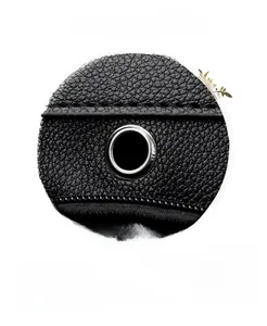 Detail of metal eyelet for headphones on black pebble grain leather backpack surface