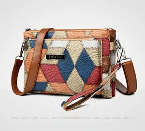 Detail of color-block patchwork leather bag with lychee texture and multi-zipper layers