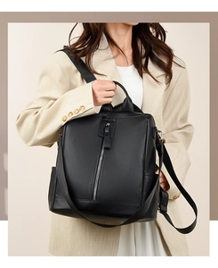 Detail of black leather backpack featuring vertical silver zippers and side pockets