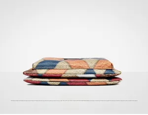Detail view of the colorful patchwork leather base and stitching quality of the clutch bag