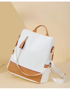 Close-up of contrast color backpack with brown PU leather base and gold zipper detail