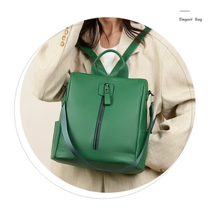 Detail of green leather backpack showing premium pebble texture and vertical zipper pocket