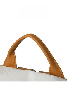 Detail of ergonomic yellow leather handle with stitching on white textured backpack