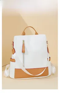 Detail view of stylish white and brown two-tone backpack with elegant gold hardware accents