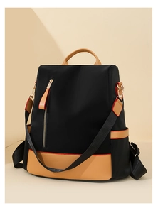 Detail view of large nylon backpack featuring black and khaki patchwork with side pockets