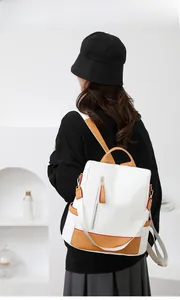 Rear view of a model wearing a minimalist beige and khaki large capacity travel backpack