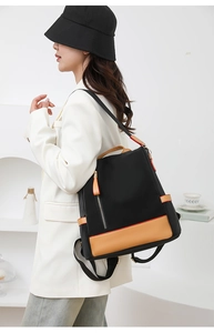 Detail of a large capacity nylon backpack with khaki leather accents on female model