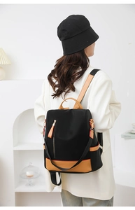 Close-up of black and brown two-tone large capacity backpack with side pocket and sleek zipper