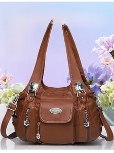 Detail of a brown soft leather handbag showing functional multi-pockets and metal floral charms