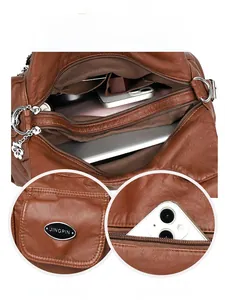 Detail view of large storage compartments and secure pockets on a brown leather handbag