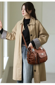 Detail of vintage brown multi-pocket faux leather shoulder bag with metallic logo