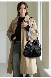 Detail of vintage black multi-pocket handbag with floral zipper pulls and PU leather texture