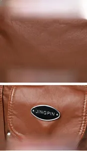 Macro detail of brown leather texture and oval metal emblem on a stylish shoulder bag