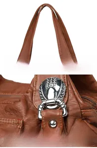 Detailed view of durable silver-tone hardware and thick faux leather handles on a brown bag