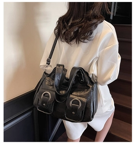 Detail of vintage black PU tote featuring silver D-ring pockets and adjustable strap
