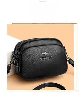 Detailed close-up of three-layer zipper compartments on black pebbled leather crossbody bag