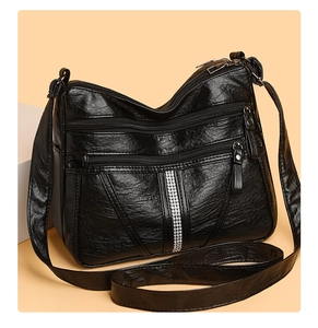 Detail showing soft black PU leather texture and dual zipper pockets on crossbody bag