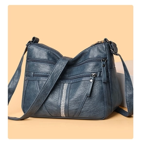 Detail view of large capacity dark teal crossbody bag with functional multi-zippers