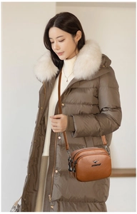 Detail of vintage brown leather crossbody bag with three-tier zippers and brand logo