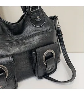 Detail of vintage black PU leather tote bag with round ring flap pockets and zip closure