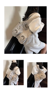 Detailed close-up of retro gray tote bag with large silver rings and soft pleated leather