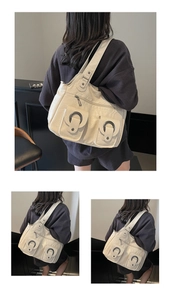 Detail view of cream white tote bag featuring metallic rings and soft leather texture