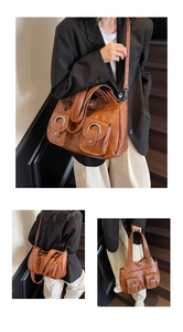 Detail view of brown vintage tote bag showing front flap pockets and metallic rings