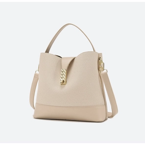 Detail of beige canvas tote bag with textured surface and golden twist-lock closure