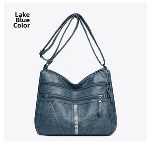 Detail of lake blue crossbody bag with multiple zippers and rhinestone decoration