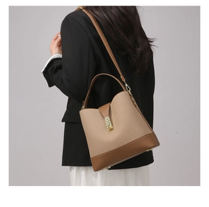 Detailed side view of two-tone canvas and leather tote bag worn by a model