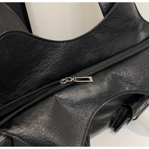 Close-up of litchi texture black leather tote bag with premium metal zipper detail
