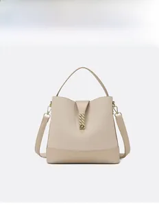 Detail of beige woven bucket bag featuring premium leather trim and gold metal buckle