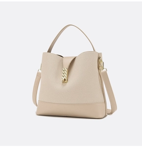 Detail of beige canvas and leather bucket bag with gold chain and crossbody strap