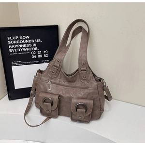 Detailed view of tan retro tote bag with multiple pockets and metal ring buckles