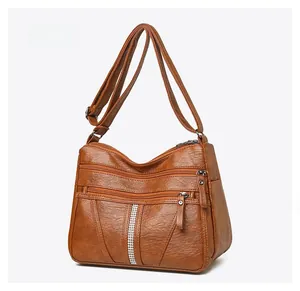 Macro side view of a brown vintage leather shoulder bag with rhinestone detail and multi-pockets